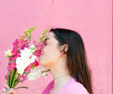 A woman feeling worthy and smelling flowers