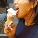 A woman expressing sensuality while licking ice cream