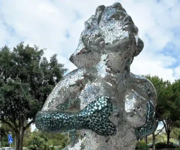 A statue of a mermaid giving herself a breast massage